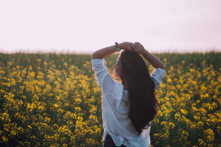 woman standing near yellow flowers